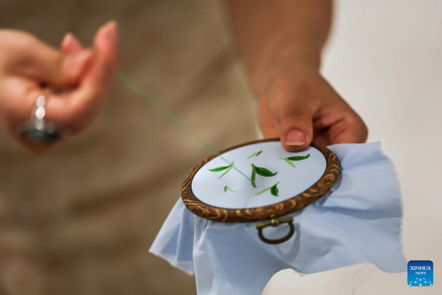 A tea master demonstrates Suzhou embroidery during a Chinese tea cultural event in Budapest, Hungary, on May 19, 2026. [Photo by David Balogh/Xinhua]